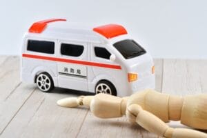 床に倒れている人形と救急車_photoAC